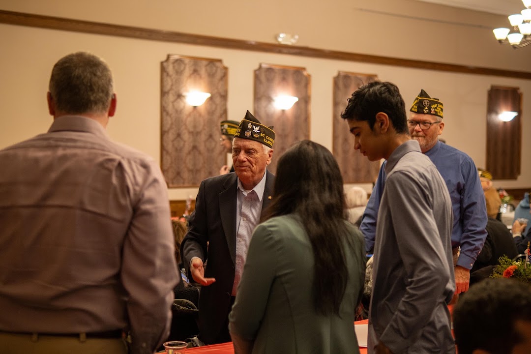 A Post 5036 veteran talks with students at a local recognition gathering